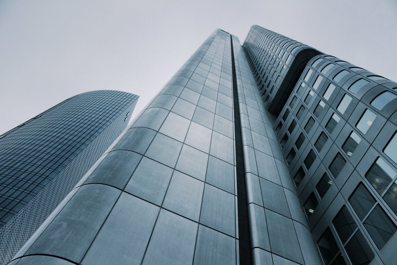 Low angle view of modern skyscrapers with glass and steel design. Perfect for corporate imagery.